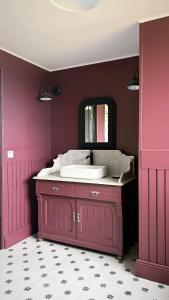 a pink bathroom with a sink and a mirror at L'atelier de la Tour - Gite indépendant entièrement équipé in Le Plessis-la-Tour