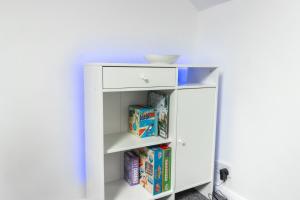 a white book shelf with cereal and a bowl on top at Charming 3 Bed House with Garden in Bickley
