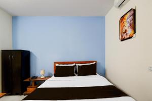 a bedroom with a bed and a blue wall at Hotel O RUBY GRAND INN in Hyderabad