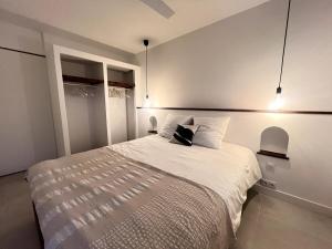 a bedroom with a large white bed with two pillows at Le Veloutier by Hestia LCD, 1 chbre avec SPA privé in Bois de Nèfles