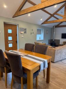 a dining room with a table and chairs and a couch at Beautiful Barn Conversion Wyboston in Bedford