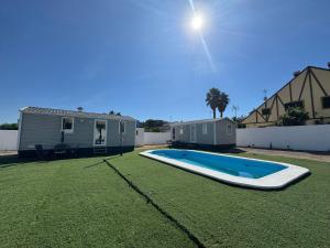 a swimming pool in a yard next to a house at Coral Bungalow in Isla Canela