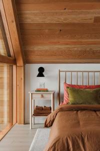 a bedroom with a bed and a white table at Camp Haliburton - Waterfront A-Frame in Wilberforce +46 photos