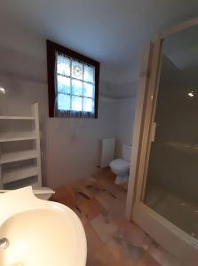 Un baño con lavabo, inodoro y ventana. en Appartement Txikia, en Amotz