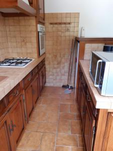 Una cocina con gabinetes de madera y piso de baldosas. en Appartement Txikia, en Amotz