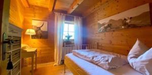 a bedroom with a bed and a window at Alpenchalet am Golfplatz in Achenkirch