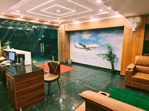 Una oficina con un cuadro de un avión en la pared. en Keerthis Comforts -Near Kempegowda international Airport Hotel, en Bangalore