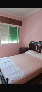 a bedroom with a bed and a window at Great flat near shops, food and beach in M'diq +7 photos