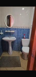 a bathroom with a sink and a toilet and a mirror at Great flat near shops, food and beach in M'diq