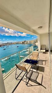 a balcony with chairs and a view of the water at Sliema Seaview Apartment- Valletta Views - APT 8, 49 Tigne Point Mansions in Sliema
