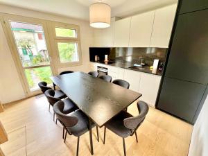 Una cocina con mesa de comedor y sillas. en WA - Luxury House - Zug - 8 Pax, en Arni Alp