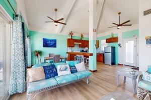 Una sala de estar con un sofá azul y una cocina. en Suite E302 @ Mara Laguna, en San Pedro
