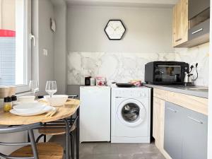 cocina con lavadora blanca y mesa en Reina Apartments Skopje with FREE Parking, en Skopje