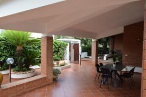 Un patio con mesa y sillas y plantas. en Villa Francesca Luxury Rooms, en San Demetrio Corone