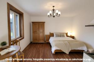 a bedroom with a bed and a window and a chandelier at Lawendowy Domek agroturystyka, noclegi - okolice Bałtowa in Bałtów