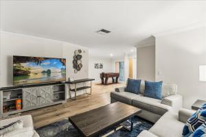 a living room with a couch and a tv at Dream Home Family Retreat 4BR Near the Gulf in Palm Harbor