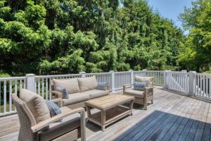 a deck with chairs and a couch and a table at Haven on Glynn by Rove Travel - Coastal Luxury in Shelter Island Heights