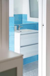a bathroom with a white sink and blue tiles at Luxury apartment Villa Vera Mondello beach with pool in Palermo