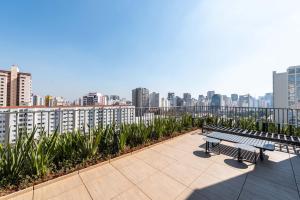 a balcony with two benches and a city skyline at Edificio Le Petit - Próx Metrô Vila Mariana in Sao Paulo