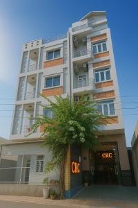 a tall building with a tree in front of it at CKC Motel - Near Can Tho City Center in Can Tho