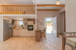 a kitchen with white cabinets and a wooden floor at Anamniseis Giorgio Falasarna in Plátanos