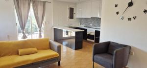 a living room with a couch and a chair in a kitchen at Apartamento LaPlaza Villamartin in Los Dolses