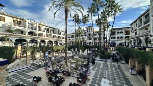 an empty courtyard with palm trees and buildings at Apartamento LaPlaza Villamartin in Los Dolses