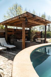 a wooden pergola and a swimming pool in a yard at Cabaña de lujo en La Serena in La Serena