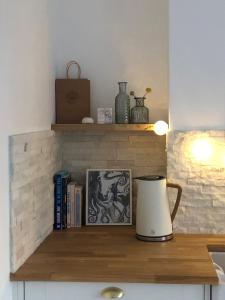 a counter with a shelf with books and a vase at Entire Apartment in Pretty Coastal Village in Cubert