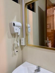 バコロドにあるYuhum Bed & Breakfast - Mandalaganの白い洗面台と鏡のあるバスルーム +36枚の写真