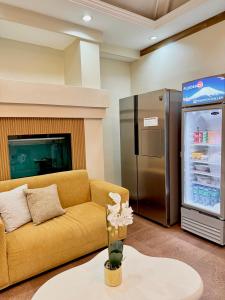 バコロドにあるYuhum Bed & Breakfast - Mandalaganのソファと冷蔵庫のあるリビングルーム