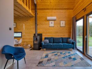 a living room with a blue couch and a fireplace at Dom nad Stawem in Wielgie