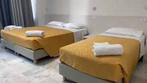 zwei Betten in einem Hotelzimmer mit Handtüchern darauf in der Unterkunft M9 Rest House Venice in Venedig