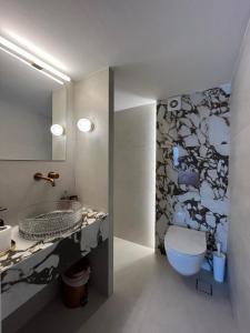 une salle de bain avec toilettes, lavabo et miroir dans l'établissement Golden Sky 1 Apartment, à Peraia 34 autres photos
