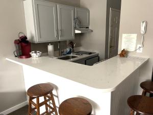 ハンコックにあるDeluxe Ski On Off 1BR Suite Sleeps 4 on Jiminy Mtnのキッチン(白いカウンタートップ、スツール付)