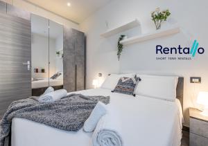 米兰Santa Giulia Olympic Arena Suite - 15 minutes from the Duomo的卧室里有一张白色的床和一面镜子