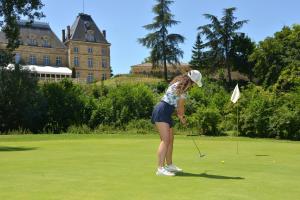 una mujer jugando al golf frente a un castillo en Best Western Golf d'Albon, en Albon 27 fotos más