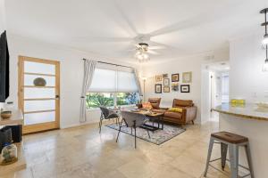 a living room with a ceiling fan and a table at CasaBreeze Cozy Creek House/IRB&Clearwater Beach! in Largo