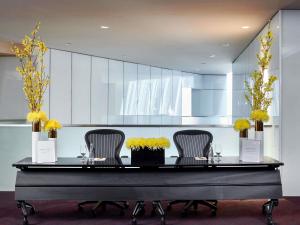 une table avec trois chaises et des fleurs jaunes sur elle dans l'établissement Sofitel Chicago Magnificent Mile, à Chicago