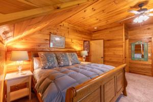 Un dormitorio con una cama en una cabaña de troncos en Hemlock Hideaway, en Boone