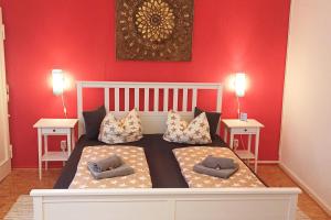a bed in a room with a red wall at 2Bed Old Town Apt Sleeps 6 - Rooftop Terrace Wifi in Cochem