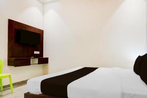 a bedroom with a bed and a tv on a wall at Hotel O Om Sai inn in Prayagraj