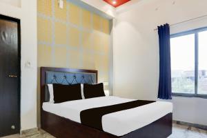 a bedroom with a large bed and a window at Hotel O Om Sai inn in Prayagraj