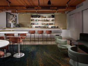 a restaurant with tables and chairs and a bar at Pullman Melbourne City Centre in Melbourne