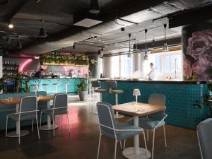 a restaurant with tables and chairs and a bar at Pullman Melbourne City Centre in Melbourne
