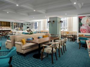 a restaurant with a couch and a table and chairs at Pullman Melbourne City Centre in Melbourne