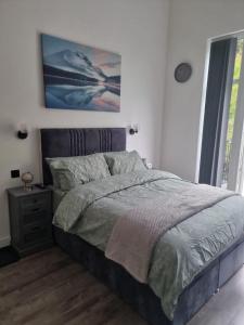 a bedroom with a bed and a painting on the wall at Brand new modern, quirky and stylish studio apartment in Wincobank
