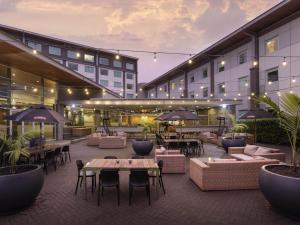 an outdoor patio with couches and tables and umbrellas at ibis Auckland Ellerslie in Auckland