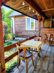 a wooden deck with a table and chairs on it at Lawendowy Domek agroturystyka, noclegi - okolice Bałtowa in Bałtów