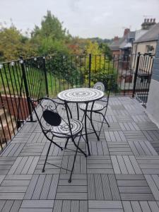 a table and two chairs on a balcony at Brand new modern, quirky and stylish studio apartment in Wincobank